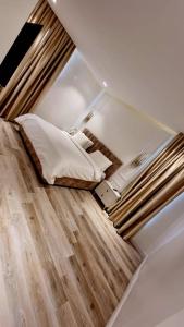 a small room with a bed and a wooden floor at Orion_apartments in Lagos