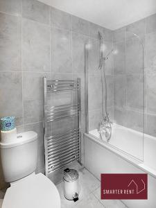 a bathroom with a toilet and a tub and a shower at Guildford - 2 Bedroom House in West Clandon