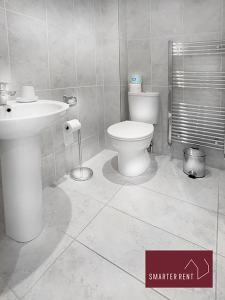 Guildford - 2 Bedroom House في West Clandon: حمام به مرحاض أبيض ومغسلة