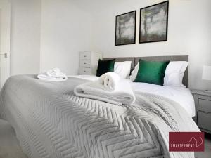 a bedroom with a bed with towels on it at Knaphill, Woking - 3 Bed House - With Garden in Brookwood