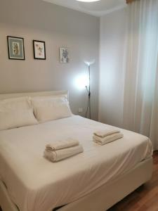 Un dormitorio con una cama blanca con dos toallas encima. en PERFECT APARTMENT for centre and Miramare, en Trieste