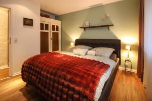 1 dormitorio con 1 cama con manta roja en Birgits Landhaus Willingen, en Willingen