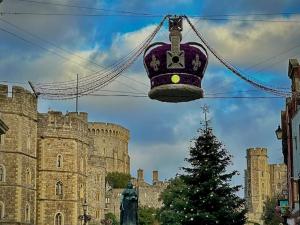 a bell hanging in front of a castle with a christmas tree at Romantic Royal Windsor in Windsor