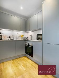 伊頓的住宿－Eton, Windsor - 1 Bedroom First Floor Apartment - With Parking，厨房铺有木地板,配有白色橱柜。