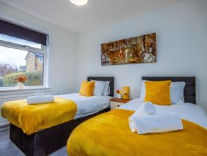 two beds in a room with yellow and white at Perfect For Long Stays With Driveway Parking in Southampton