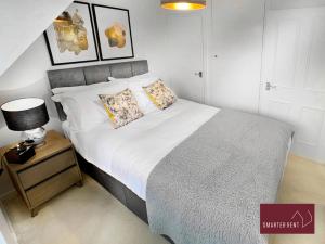 a bedroom with a large bed and a night stand at Wokingham - 2 Bedroom Maisonette - With Parking in Wokingham
