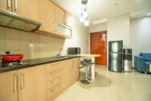 a kitchen with wooden cabinets and a red bowl on the counter at Comfy 1-bedroom city view @ central Jakarta, SCBD in Jakarta