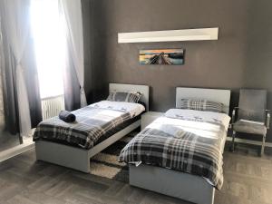 een slaapkamer met 2 bedden en een stoel bij Pellinger-Höhe Apartment in Pellingen