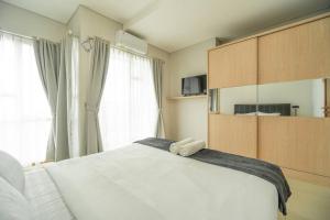 1 dormitorio con 1 cama blanca grande y ventana grande en Comfy 1-bedroom city view @ central Jakarta, SCBD, en Yakarta