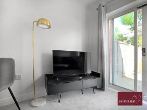 a living room with a flat screen tv on a dresser at Wokingham - 2 Bedroom House - With Garden in Winnersh
