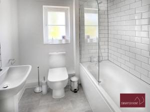 a bathroom with a toilet and a tub and a sink at Wokingham - 2 Bedroom House - With Garden in Winnersh