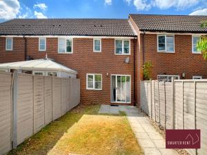 a brick house with a fence in front of it at Wokingham - 2 Bedroom House - With Garden in Winnersh