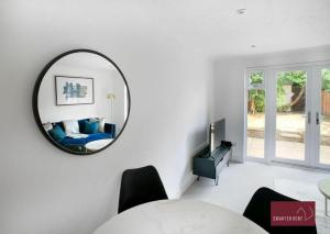 a living room with a mirror on the wall at Twyford - Modern 2 Bedroom House - Garden and Parking in Twyford