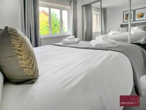 a large white bed with towels on top of it at Twyford - Modern 2 Bedroom House - Garden and Parking in Twyford