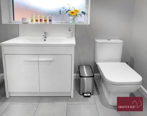 a white bathroom with a sink and a toilet at Maidenhead- 3 Bedroom House With Garden in Maidenhead