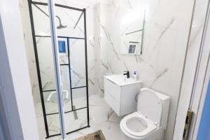 a white bathroom with a toilet and a sink at Rivendell Chalet in Valea Ierii