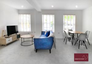 a living room with a blue couch and a tv at Eton, Windsor - 1 Bedroom Ground Floor Apartment - With Parking in Eton