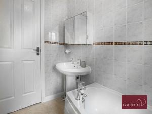EasthampsteadにあるBracknell - 2 Bedroom House With Garden and Parkingの洗面台とバスタブのある白いバスルーム +6枚の写真