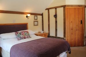 a bedroom with a bed and a wooden door at Woodman's Farm in Norwich