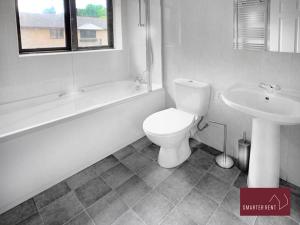 a white bathroom with a toilet and a sink at Maidenhead - Gated Parking Balcony in Maidenhead