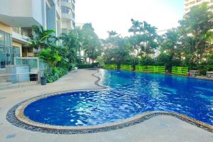 a large blue swimming pool next to a building at Spacious 2BD, 1min BTS Central Ladprao Jodd Fair Night Market in Bangkok
