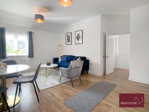 a living room with a blue couch and a table at Jennetts Park, Bracknell - 2 Bedroom Maisonette With Parking in Bracknell