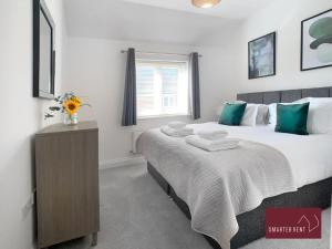 a bedroom with a large bed and a dresser in it at Jennetts Park, Bracknell - 2 Bedroom Maisonette With Parking in Bracknell