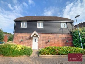a black house with a white door and a brick building at Jennetts Park, Bracknell - 2 Bedroom Maisonette With Parking in Bracknell