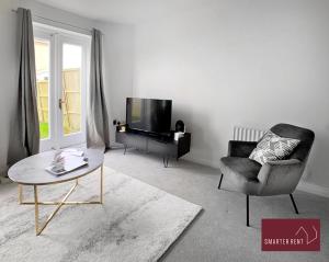 a living room with a chair and a television at Bracknell - 2 Bedroom Home With Garden & Parking in Easthampstead