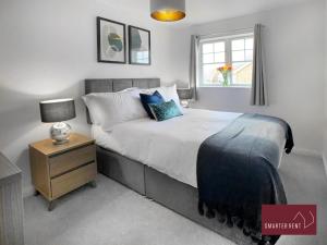 a bedroom with a bed with a nightstand and a window at Bracknell - 2 Bedroom Home With Garden & Parking in Easthampstead