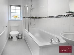 a bathroom with a tub and a toilet and a sink at Bracknell - 2 Bedroom Home With Garden & Parking in Easthampstead