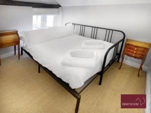 a bed with white sheets and two towels on it at Henley-On-Thames - 2 Bedroom Cottage With Permit Parking Close By in Henley on Thames