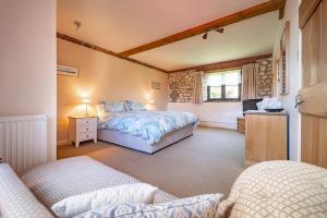 ein Schlafzimmer mit einem Bett und einem Sofa in einem Zimmer in der Unterkunft Oyster Barn in Titchwell