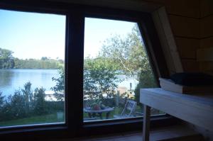 a window view of a lake from a house at Reetdachkate auf Gestüt Schierensee in Grebin