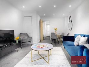 uma sala de estar com um sofá azul e uma mesa em West End, Woking - 2 Bed House With Parking and Garden em Bisley