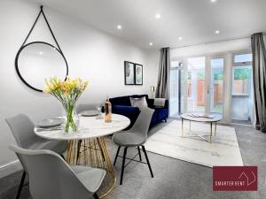 sala de estar con mesa y sofá azul en West End, Woking - 2 Bed House With Parking and Garden, en Bisley