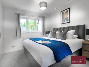 een slaapkamer met een groot bed en een raam bij West End, Woking - 2 Bed House With Parking and Garden in Bisley