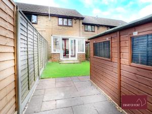 a house with a wooden fence and a yard at West End, Woking - 2 Bed House With Parking and Garden in Bisley