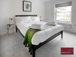 a bedroom with a bed with white sheets and a window at Eton, Windsor - 1 Bedroom First Floor Apartment - Parking in Eton
