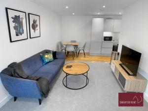 a living room with a blue couch and a table at Eton Windsor - 1 Bedroom Flat - With Parking in Eton