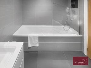 a white bathroom with a tub and a sink at Eton Windsor - 1 Bedroom Flat - With Parking in Eton