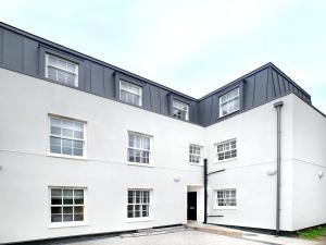 a white building with a black roof at Eton Windsor - 1 Bedroom Flat - With Parking in Eton