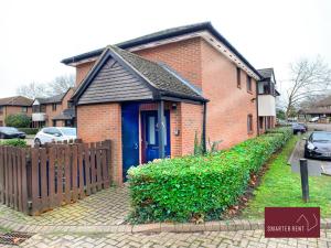 a brick house with a blue door and a fence at Lovely Apartment, Maidenhead in Maidenhead