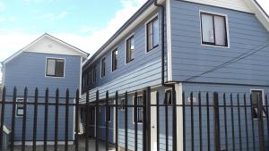 two houses next to each other with a fence at Departamentos Arlenne II in Valdivia