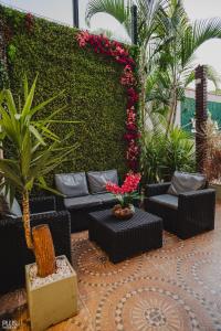 een patio met zwarte meubels en planten en bloemen bij Hotel Yvera Cataratas in Puerto Iguazú