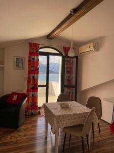 a living room with a table and chairs and a window at Apartment Jovana in Kotor