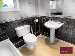 a bathroom with a toilet and a sink at 2 Bed House with Garden, Woking in Chobham
