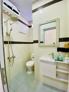 ein Badezimmer mit einem WC, einem Waschbecken und einem Spiegel in der Unterkunft SAM HOMESTAY HUE in Hue