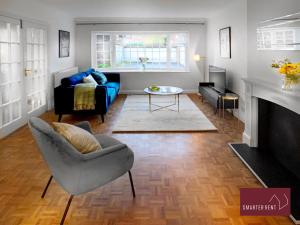 uma sala de estar com um sofá azul e uma lareira em Maidenhead - Lovely Modern 3 bedroom house em Maidenhead