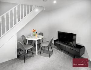 d'une salle à manger avec une table, des chaises et une télévision. dans l'établissement Yateley - Spacious 2 Bedroom House, à Finchampstead
